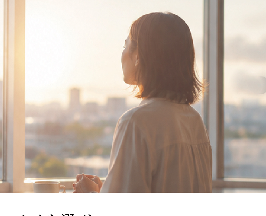 窓辺で朝日を眺める女性